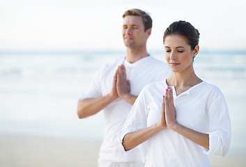 Image showing Couple, yoga and ocean with meditation, zen and waves on sand in morning with mindfulness in summer. Man, woman and outdoor for namaste with spiritual growth, balance or peace at beach in Cape Town