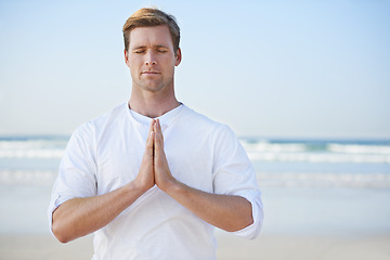 Image showing Man, meditation on beach and prayer for zen, wellness and holistic healing outdoor for calm and yoga. Ocean, fresh air and travel with mindfulness for peace of mind, wellbeing and spiritual in nature