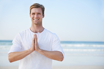 Image showing Man, yoga and beach with smile in portrait for peace, zen and space for mockup on vacation with meditation. Person, ocean and outdoor in summer for namaste with nature on spiritual journey by sea