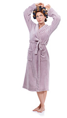 Image showing Hair, rollers and bathrobe with confused woman in studio isolated on white background for pampering. Wellness, beauty and morning with young person in bathroom to relax for haircare treatment