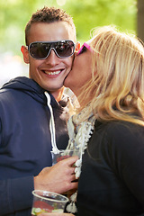 Image showing Kissing, festival and outdoor with couple, love and happiness with fun and excitement on a weekend break. Portrait, man and woman with romance or sunglasses with event or party on a vacation or smile