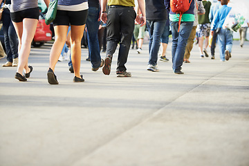 Image showing Crowd, legs and people on road walking on holiday vacation or weekend to travel or fun in city. Social, festival or shoes of community outdoors for group activity, event and commute in urban town