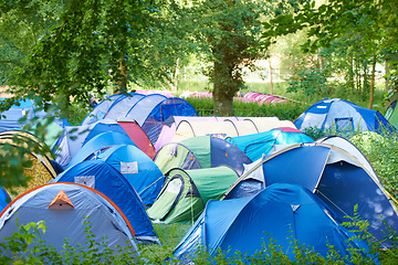 Image showing Camping, tents and outdoor music festival in park on holiday or vacation in summer forest. Camp, site and shelter setup at party, event or travel in woods for concert, adventure and crowded carnival