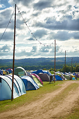 Image showing Camping, tents and outdoor music festival in park for celebration on holiday vacation in summer. Campsite, background or shelter at party, event or travel in nature for concert or crowded carnival