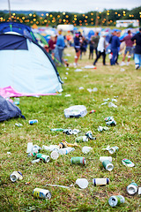 Image showing Field, festival and litter with drinks, beer and beverage product for drinking a can in party. Concert outdoor pollution or alcohol on ground, grass or floor by trash or garbage with dirt or mess