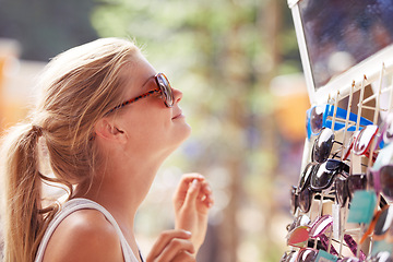 Image showing Woman, buying sunglasses and shopping at market outdoor in summer with consumer at flea store. Sales, person and purchase shades at shop, decision and retail choice of customer trying eyewear gift