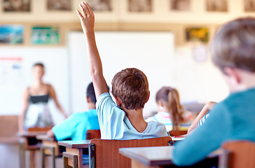 Image showing Question, student and hand raised for help in classroom, solution and boy at school. Male person, back and curious for answer or information, learning and study or education for growth in childhood