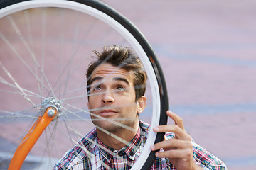 Image showing City, check and man with bicycle wheel, sunshine and road with guy and transportation with sustainability. Bike inspection, person and hipster with maintenance and eco friendly with cycling and Italy