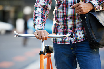 Image showing Hands, person and push bike in street to travel on eco friendly transport outdoor, commute or walking on trip. Cycling, bag and bicycle in urban town, city or road for journey or closeup in summer