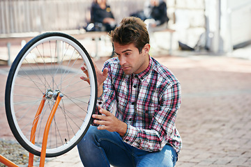 Image showing Maintenance, bicycle and wheel with man, city and inspection with adventure and fixing bike. Cyclist, guy and outdoor with person and travel with transportation and eco friendly with sustainability