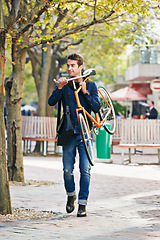 Image showing Man carrying his bicycle, travel and sunshine in a city, sustainability and commute for adventure and vacation. Netherlands, person and guy with a bike and eco friendly with transportation and summer