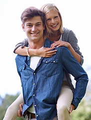 Image showing Portrait, smile and piggyback with couple in countryside together for love, romance or bonding. Happy, date or hugging with young man carrying woman outdoor in nature for hiking or adventure