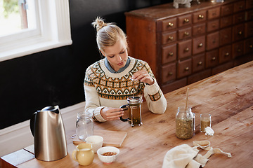 Image showing Woman, herbal tea and prepare with leaves at kitchen table with french press or kettle for health, beverage or detox. Female person, plunger and relax morning for breakfast drink, vacation or home