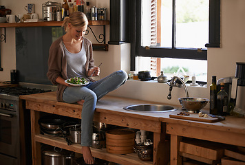Image showing Happy, woman and eating salad in home kitchen, nutrition and fresh leafy greens for healthy diet. Vegetables, bowl and hungry person with fork for food, lunch and organic vegan meal for wellness