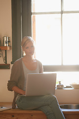 Image showing Woman, kitchen and laptop with window, portrait and computer for connection and internet. Copywriter, technology and research for blog, freelance and remote content for planning or working from home