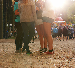 Image showing Legs, forest and group of friends at festival together for social event, party or summer celebration. Flare, crowd and people in woods for talking, bonding or free time in nature with audience