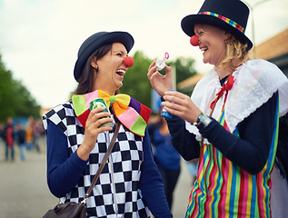 Image showing Clown, people and outdoor at festival, carnival or costume for event or concert in park. Happy, women and smile in funny props, clothes and dress up for culture, party in summer or holiday bubbles