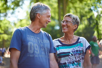 Image showing Mature, couple and walking in forest with happy adventure or travel on holiday in summer for vacation. People, smile and relax outdoor in park, woods or together in nature at event or festival