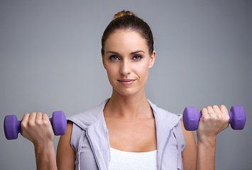 Image showing Happy woman, portrait and dumbbells for weightlifting, fitness or exercise on a gray studio background. Face of active, female person or athlete for strength, muscle gain or workout on mockup space