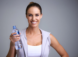 Image showing Fitness, portrait and happy woman with water in studio for training, wellness or detox on grey background. Sports, bottle and face of female model with liquid hydration for body workout recovery