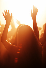 Image showing Woman, live and festival with arms raised to listen, music and dance with crowd, cheering and dancing to performance on stage. Audience, enjoy and singing with loud, sound and partying with band.