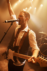 Image showing Night, singer and guitar with man on stage for music, performance and rock show. Event, spotlight and concert with male musician playing instrument at festival club for rave, disco and celebration