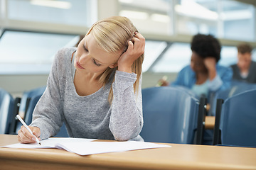 Image showing Woman, writing or college student learning with notes in class, auditorium or lecture for education. University, classroom or people in campus for knowledge or studying a course in academy or school