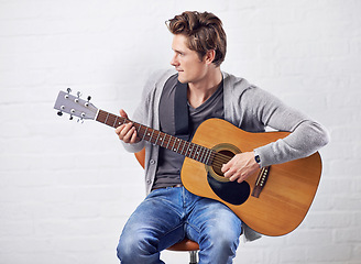 Image showing Man, guitar and musician with art and music, acoustic for entertainment and performance against wall background. Busker, artist and musical instrument for creativity, track or song with talent