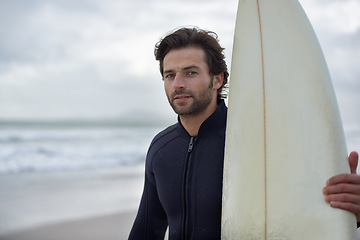 Image showing Man, portrait and surfer on beach for fitness, sport or waves on shore in outdoor exercise. Young male person or athlete with surfboard for surfing challenge or hobby on ocean coast or sea in nature