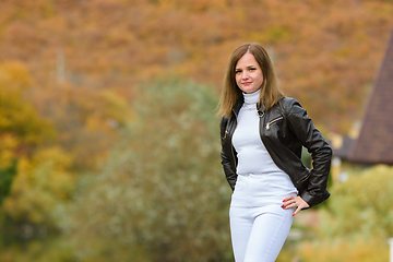 Image showing Young beautiful girl in casual clothes against the background of a blurred autumn forest