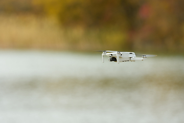 Image showing Unmanned aerial vehicle close-up against the background of an autumn landscape