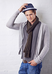 Image showing Hat, fashion and portrait of man by wall with casual, cool and trendy outfit for confidence. Smile, handsome and happy young male person with attractive style standing by white brick background.