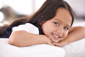 Image showing Happy, relax and portrait of child on sofa for playful, fun and resting on weekend in living room. Smile, childhood and face of young girl alone on couch for vacation, holiday and free time in home