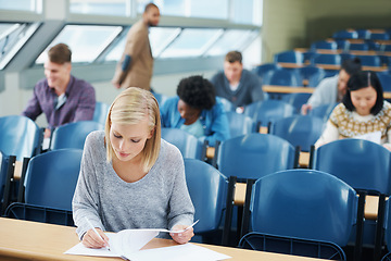 Image showing Writing, university and woman student in classroom studying for test, exam or assignment. Education, scholarship and female person working on project with knowledge in lecture hall for learning.