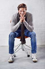 Image showing Fashion, portrait and happy man thinking on a chair with memory, insight or solution on wall background. Face, idea and male person with problem solving solution, answer or plan, inspiration or guess