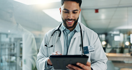 Image showing Tablet, research and happy man doctor on internet for medical or healthcare information online in a hospital. Smile, medicine and professional typing on health website or app in a modern clinic