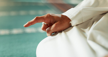 Image showing Islam, floor and closeup of a pointing finger or person at a mosque for praying, hajj or support. Muslim, hope and hand of a man for a prayer, gesture or worship for respect, religion or trust