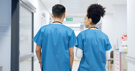 Image showing Doctors, man and woman in hallway, talking and partnership with back, discussion and ideas in clinic. Medic, nurse or surgeon teamwork with planning, brainstorming or problem solving in hospital