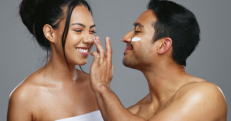 Image showing Couple, smile and love for skincare, care and portrait with moisturizer in studio by gray background. Happy people, dermatology and hug for cosmetics, hydration and creme or love for skin treatment