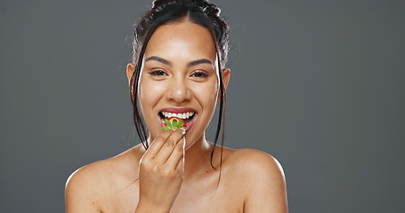 Image showing Woman, strawberry and beauty in studio for health, diet and smile on face with skincare by background. Girl, model and happy for fruit, nutrition choice and vegan food for wellness, glow or self care