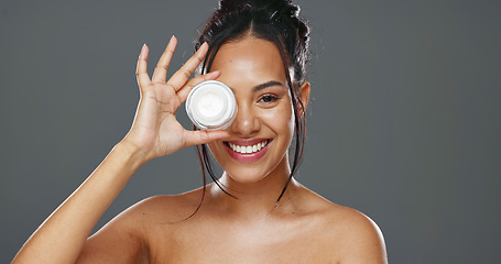 Image showing Happy woman, face and cream for skincare, beauty or cosmetics against a grey studio background. Portrait of female person smile with moisturizer, creme or lotion for facial treatment or product