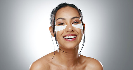 Image showing Face, eye patches and woman with skincare, cosmetics and dermatology on a grey studio background. Portrait, person and model with beauty, treatment and healthy skin with grooming, smooth and shine