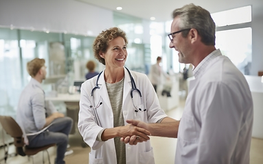 Image showing In a modern hospital corridor, doctors exchange handshakes, reflecting professional unity and collaborative teamwork