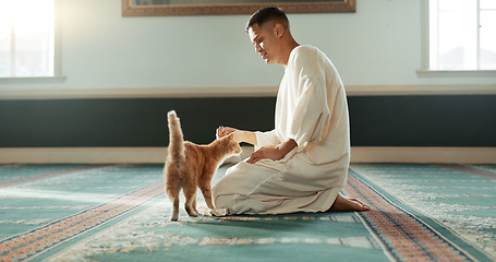 Image showing Cat, islamic and man with pet in a mosque for praying, peace and spiritual care in holy religion for Allah. Respect, gratitude and Muslim person with kindness for animal or kitten after worship