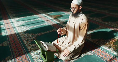 Image showing Islam, praying and man in mosque with Quran, mindfulness and gratitude in faith reading. Worship, religion and Muslim Imam in holy temple for praise with book, spiritual teaching and peace meditation