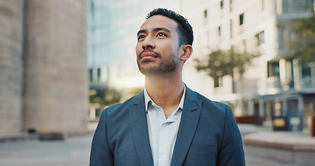 Image showing Asian businessman, city and positive by buildings in morning, office view and travel to workplace in accounting career. Young person, smile and professional with ambition and working in town in cbd