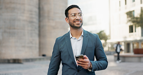 Image showing Asian businessman, mobile message and walking in city, view and confident professional in career by office buildings. Young lawyer, chat and smartphone for connection and technology in cbd in town