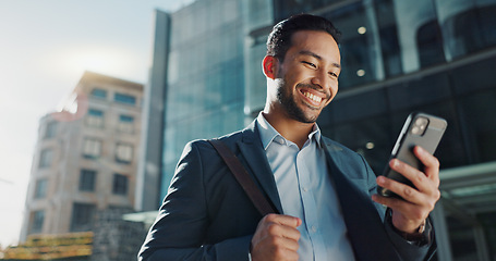 Image showing Phone, social media and wind with businessman in city, walking on street or sidewalk for morning work commute. Smile, mobile or contact with happy young employee in urban town for travel journey