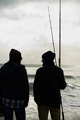 Image showing Fishing, fisherman and men by ocean talking with rod, reel and equipment to catch fish for hobby. Friends, sports and people cast line for adventure on holiday, vacation or weekend together in nature