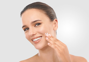 Image showing Woman, skincare and facial cream in studio for beauty, dermatology or collagen treatment. Happy, female person and product in portrait for wellness, moisturizer and cosmetics on white background